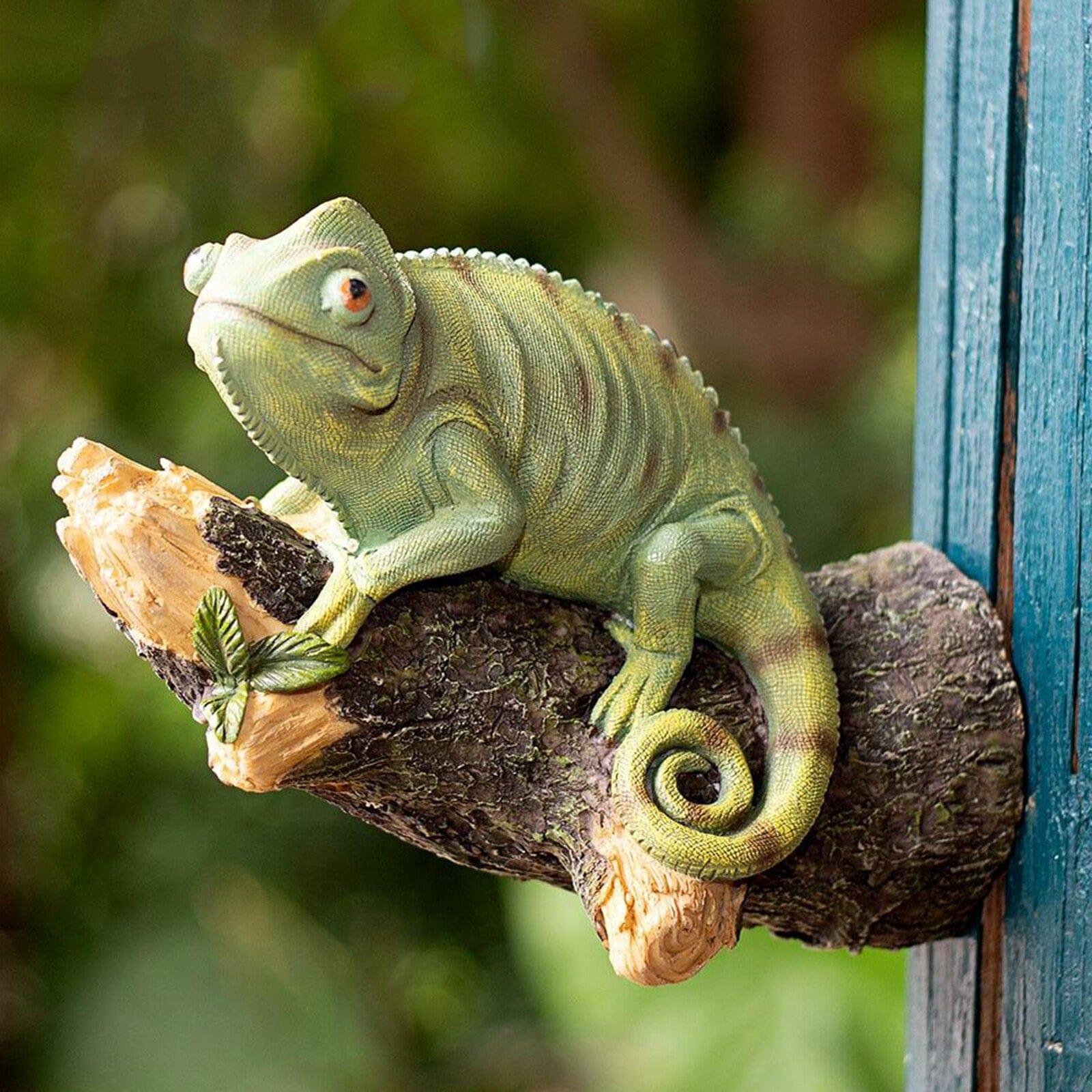 Figurinha de camaleão em resina na árvore