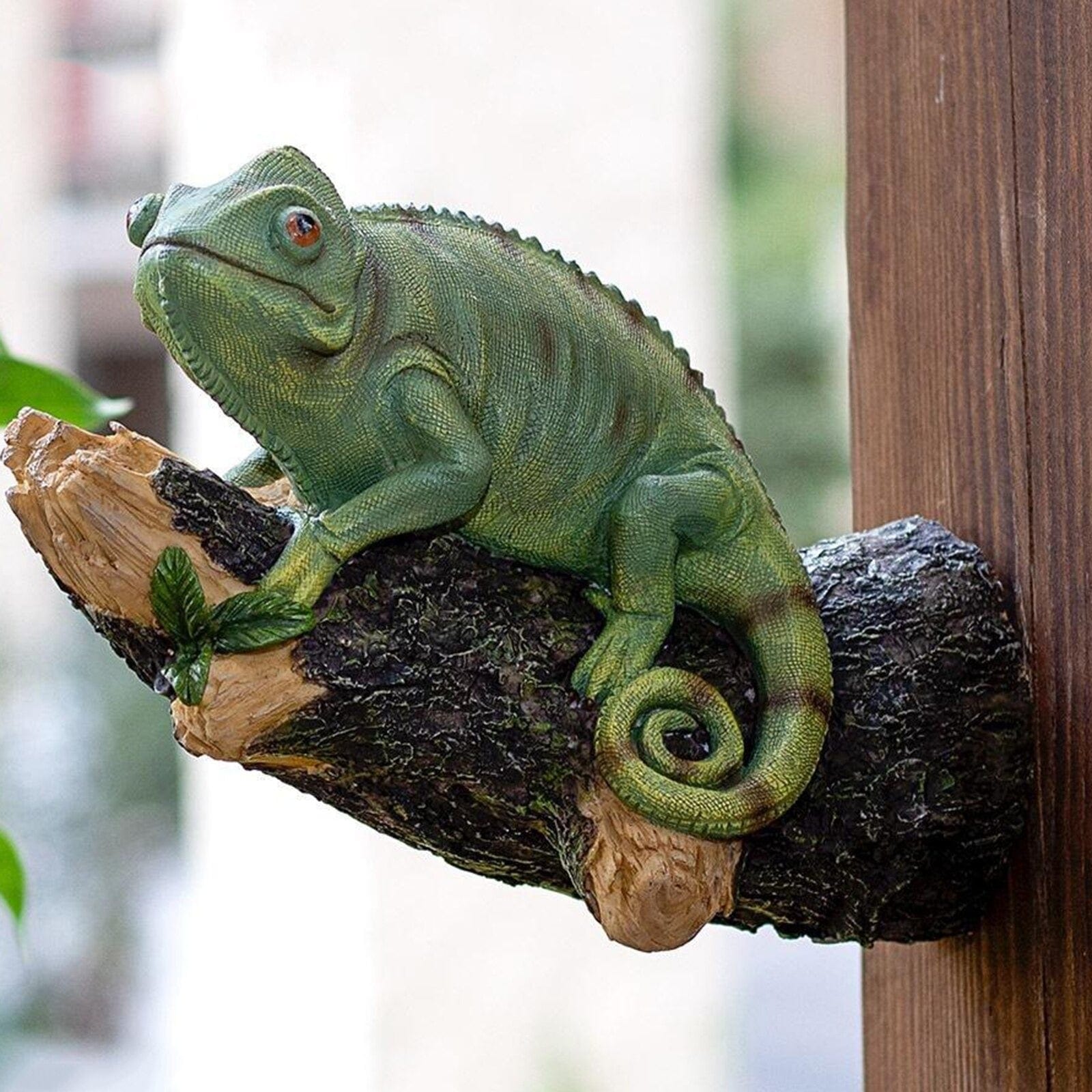 Figurinha de camaleão em resina na árvore